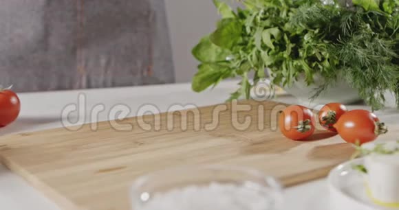 木耳的绿叶落在切割木板上女人用蔬菜西红柿奶酪做沙拉视频的预览图