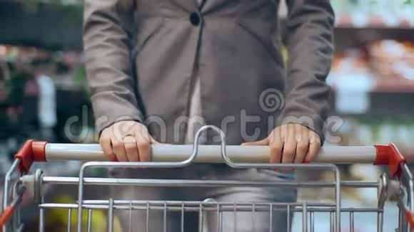一位年轻漂亮的女士带着手推车在超市散步视频的预览图
