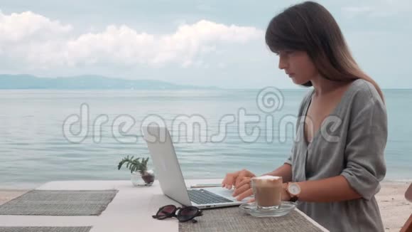 快乐年轻美丽的女人在户外使用笔记本电脑视频的预览图