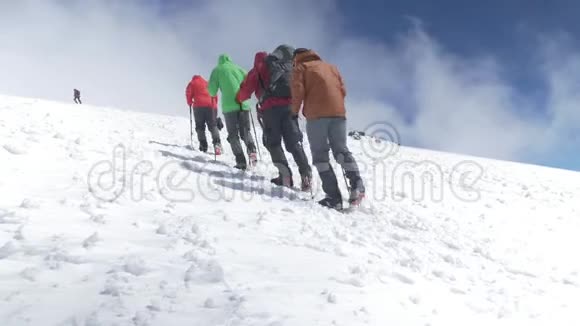 登山者登上雪坡的山顶在晴朗的天气里高加索山脉视频的预览图