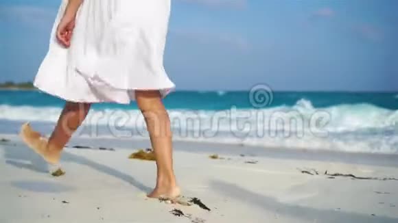 近距离的孩子腿沿着白色的海滩散步海滩度假和赤脚的概念视频的预览图