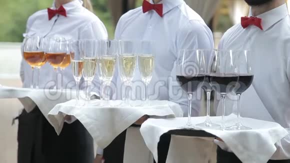 服务员用酒精饮料迎接客人托盘上有香槟红酒白酒视频的预览图