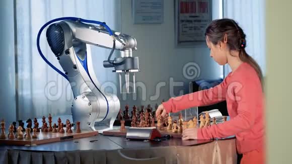 儿童天才概念聪明的年轻女孩和一个现代的象棋机器人下棋4K视频的预览图