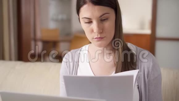 迷人的微笑专业的年轻女性在家工作拿着文件家庭办公概念视频的预览图
