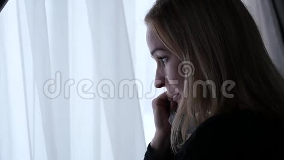 窗户附近的悲伤女孩哭着想着什么慢动作视频的预览图