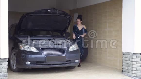 漂亮时尚的女士穿着长裙修理豪华轿车的马达视频的预览图