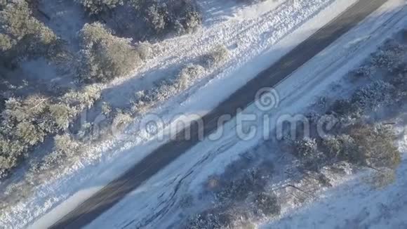 汽车在冬天的道路上行驶上面覆盖着白雪的树木视频的预览图