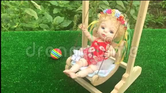 可爱的娃娃在玩具秋千上摆动视频的预览图