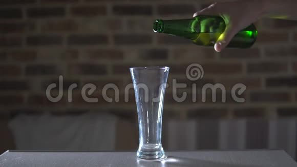 啤酒从瓶子里流入玻璃烧杯视频的预览图