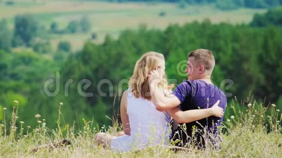 恋爱中的情侣坐在山顶上视频的预览图