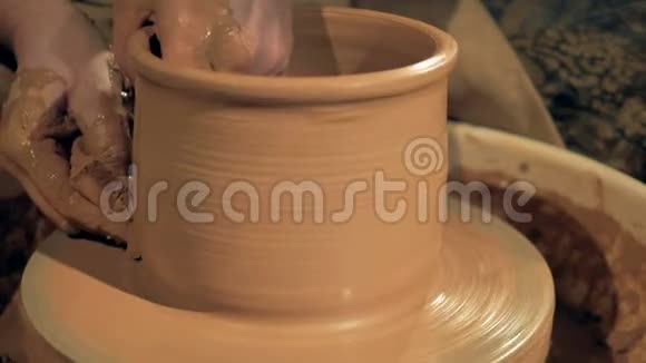 陶器工人在一个特殊的轮子上制造一个粘土花瓶视频的预览图