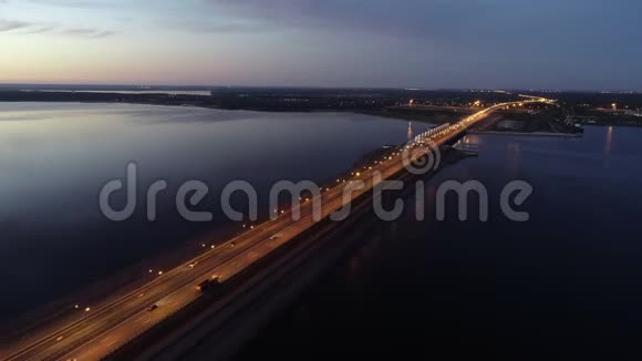 在日落黄昏时突出的公路穿过大海到城市视频的预览图