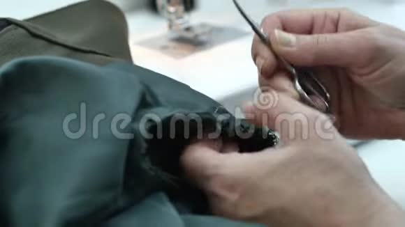一个职业女裁缝正在用缝纫机撕下一件棉衣视频的预览图