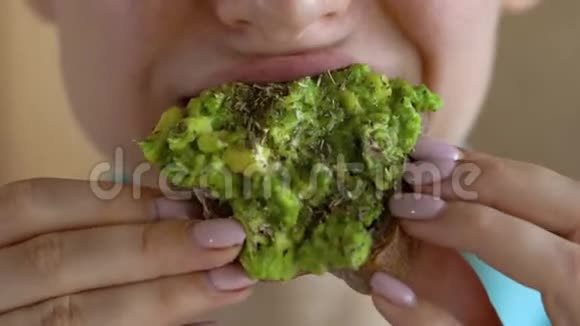 女人吃纯素鳄梨三明治特写视频的预览图