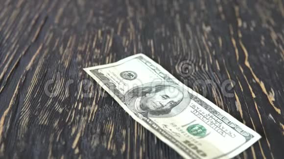 一百美元的钞票落在桌子上视频的预览图