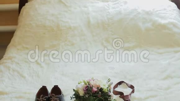 婚礼的细节婚礼鞋领带花束和戒指在椅子上视频的预览图