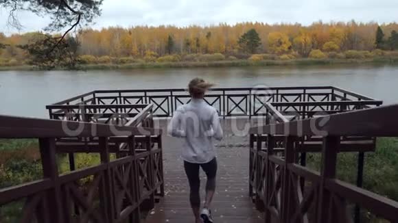 运动的女人在木墩上慢跑前热身视频的预览图