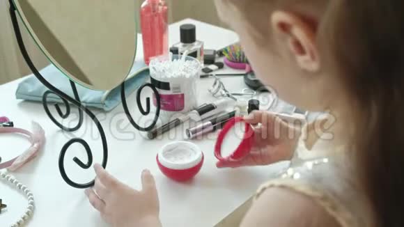 小女孩用红发涂抹乳霜照镜子化妆面部时尚时尚时尚化妆品亲密的手视频的预览图