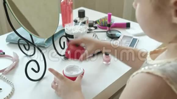 小女孩用红发涂抹乳霜照镜子化妆面部时尚时尚时尚化妆品亲密的手视频的预览图