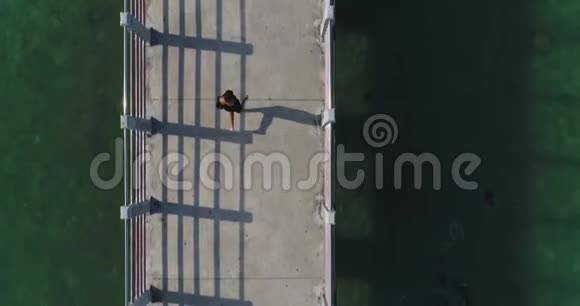 空中那个女孩正沿着海边的桥奔跑视频的预览图