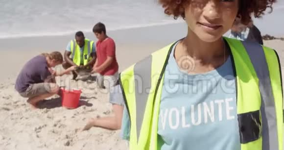 非洲裔美国女性志愿者在海滩上观看摄像机的正面景色视频的预览图