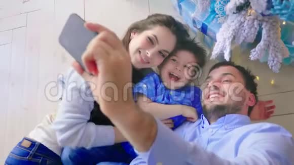 幸福家庭在圣诞节背景装饰上打电话自拍视频的预览图