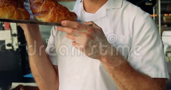 4k面包店男厨师拿着牛角面包托盘视频的预览图