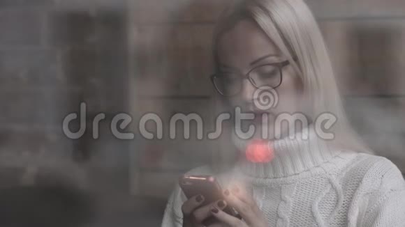 坐在咖啡馆里的女人在智能手机上聊天喝咖啡视频的预览图