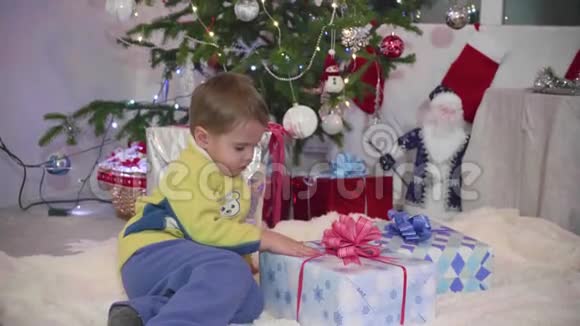 圣诞礼物惊喜一个孩子打开礼物新年和圣诞节视频的预览图