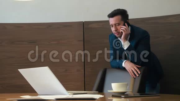 尊敬的人通过智能手机交谈坐在商务办公室的桌面上视频的预览图