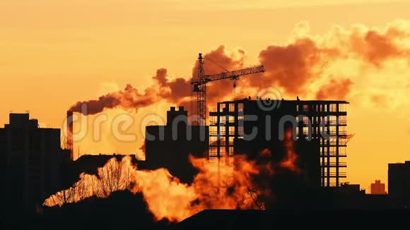 建筑住宅起重机在屋顶城市景观上的建筑工人剪影视频的预览图