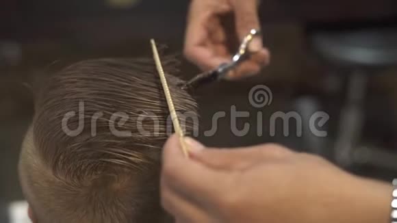 儿童美发沙龙理发师用理发剪剪头发儿童用剪刀剪发并在视频的预览图