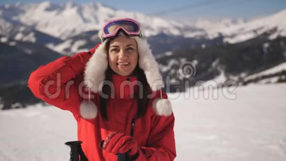 山地滑雪场女滑雪者特写肖像穿着滑雪服和滑雪护目镜看着摄像机和视频的预览图