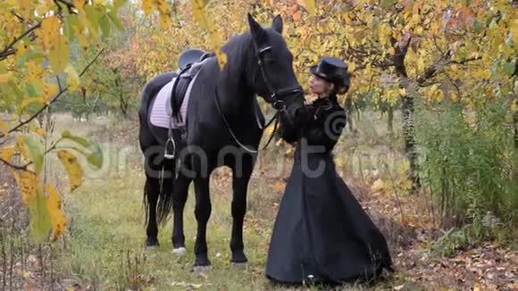 穿着黑色衣服的女马童牵着一匹黑马视频的预览图