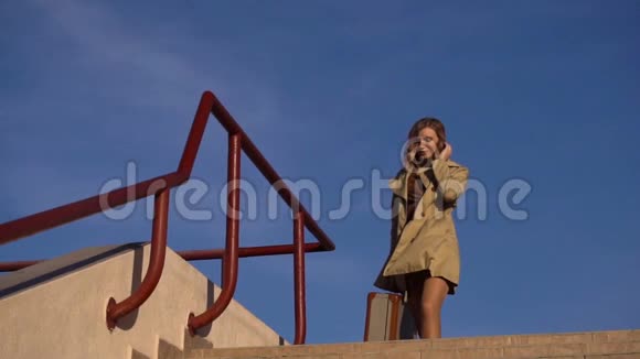 漂亮的年轻金发女人穿着扳手和高跟鞋带着老式西装下楼到游艇码头视频的预览图
