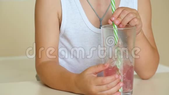 孩子用吸管把泡泡吹成一杯果汁喝鸡尾酒视频的预览图