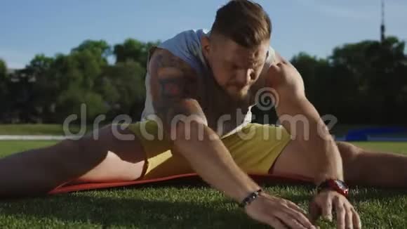运动员在绿茵场上的垫子上弯曲视频的预览图