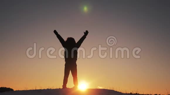 男子游客举起双手成功胜利站在山顶上剪影的冬天黎明日出视频的预览图