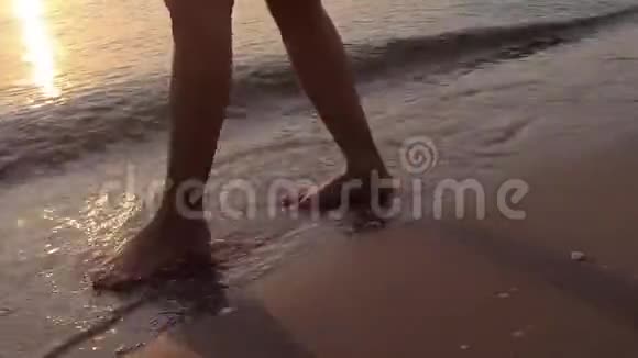录像片段日出时沙滩沙滩海浪上的女人腿视频的预览图