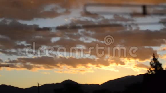 从屋顶快速移动的橙色和黄色日出云视频的预览图