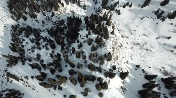 无人驾驶飞机在雪顶和雪堆上平稳下降从山顶到群山的景色无人驾驶飞机石头闪闪发光视频的预览图