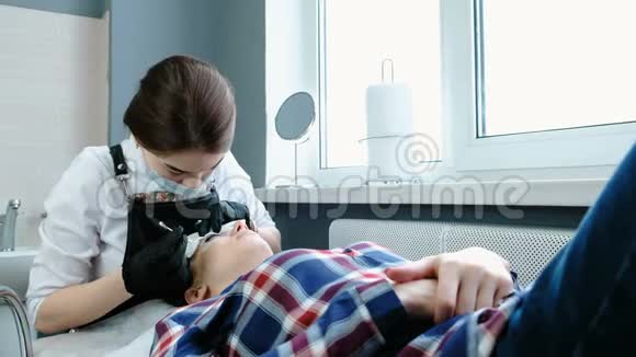 美容治疗美容师用棉花从睫毛上去除黑色油漆复合睫毛视频的预览图
