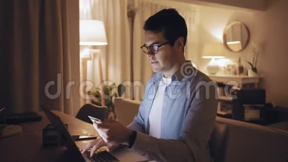 一个男人深夜用笔记本电脑和信用卡在网上购物视频的预览图