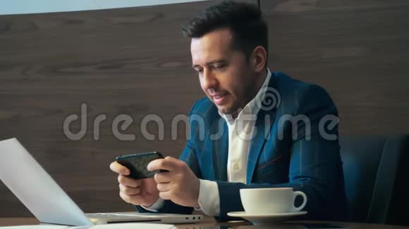 商人用手机靠在椅子上男人在办公室喝咖啡视频的预览图