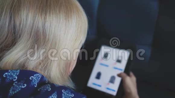 年轻女孩用平板电脑坐在家里的沙发上在网上商店里找东西购物社交媒体视频的预览图