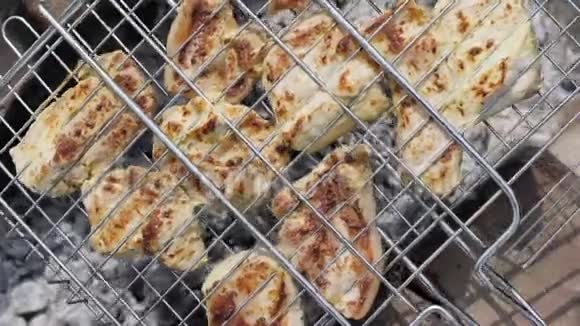 在夏季露营期间在烧烤时把切肯肉串起来视频的预览图