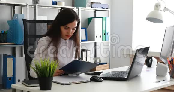 女商人在笔记本电脑上工作在现代办公室用纸写字视频的预览图