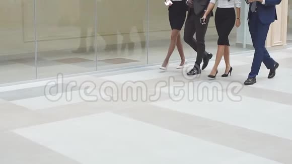 开朗的商务人士一起沿着办公走廊散步慢动作视频的预览图