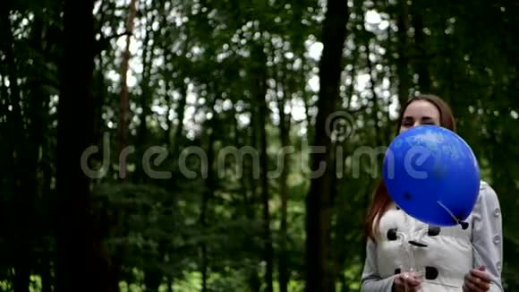 年轻女子站着在森林里玩气球视频的预览图