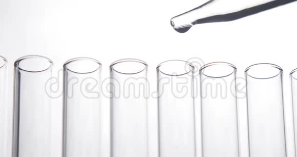 吸管将透明化学物质滴入白色背景的试管中化学和医学概念视频的预览图